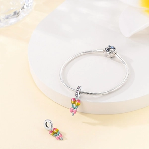 Detailed macro view of an enamel tulip charm with pink bow on a S925 silver snake chain