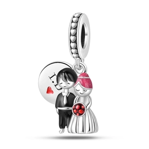 Macro detail of S925 silver wedding charm with bride, groom and heart engraving