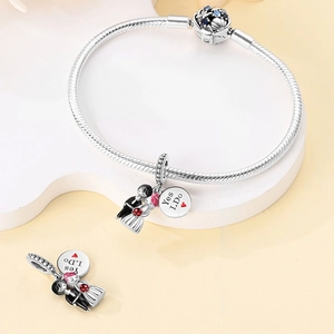 Detail of silver wedding charm bracelet with bride groom pendant and Yes I Do engraving