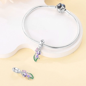 Detailed macro view of silver snake chain bracelet with purple tulip charm and zircon