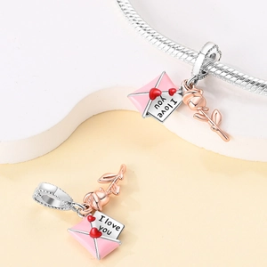 Detail of silver snake chain bracelet with pink enamel love letter and rose charms
