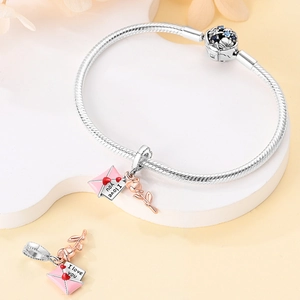 Detail of silver snake chain bracelet with rose enamel envelope and zircon flower clasp