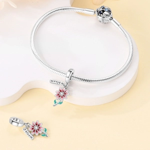 Detail of silver snake chain bracelet with pink daisy charms and bloom engraving