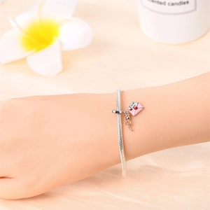 Silver snake chain bracelet featuring pink envelope and rose charms on a female wrist
