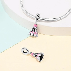 Detailed view of silver badminton charm with pink crystals and enamel on a podium