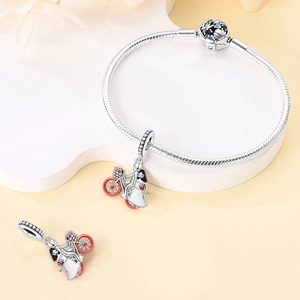 Detail of silver snake chain bracelet with blue zircon charm and bike rider pendant