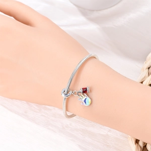 Silver snake chain bracelet with rainbow handprint charm and red enamel paint tube detail