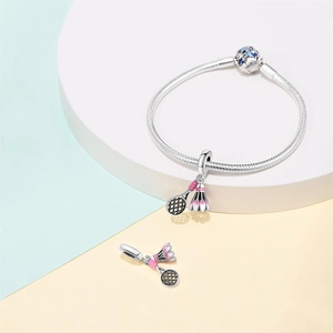 Detailed view of silver charm bracelet with pink enamel badminton racket and shuttlecock charms