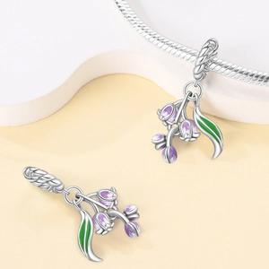 Silver lily of the valley charm with purple enamel petals on a snake chain bracelet