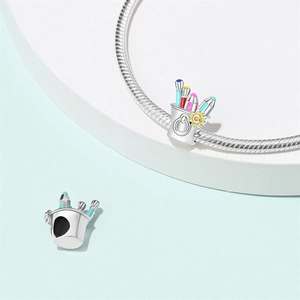 Detailed macro of silver paintbrush charms with colorful enamel and sunflower accents