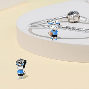 Detailed macro of a silver basketball charm with blue enamel on a snake chain bracelet