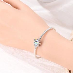 Detail of artistic palette charm with ART engraving and colorful enamel on silver bracelet