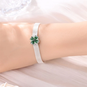 Dettaglio del bracciale a maglia argento con quadrifoglio verde e cristalli blu