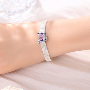 Silbernes Mesh-Armband mit lila Emaille-Schmetterling am Handgelenk im Detail