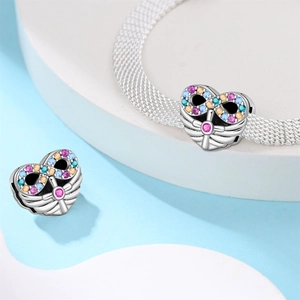 Dettaglio charm cuore infinito in argento con zirconi colorati su bracciale mesh