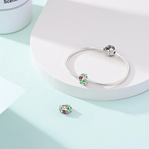 Detailed macro view of S925 sterling silver snake chain bracelet with green enamel charms