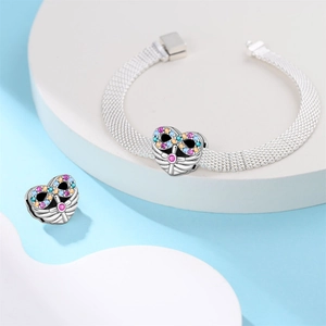 Dettaglio del bracciale mesh argento con ciondoli a cuore e pietre colorate