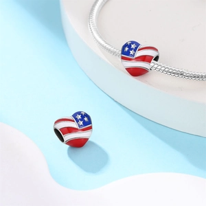 Makroaufnahme von herzförmigem US-Flaggen-Charm aus Silber mit farbigem Emaille-Dekor