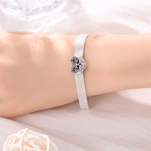 Dettaglio del bracciale a maglia argento con ciondolo a cuore e cristalli colorati