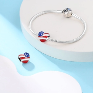 Detail eines silbernen Schlangenarmbands mit US-Flaggen-Herzanhängern für DIY-Schmuck