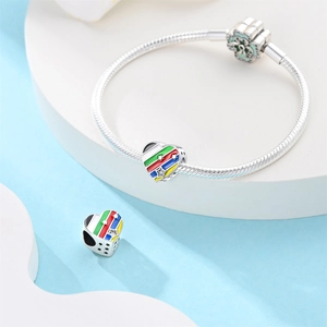 Detalle macro de la pulsera de serpiente en plata 925 con dijes de corazón coloridos