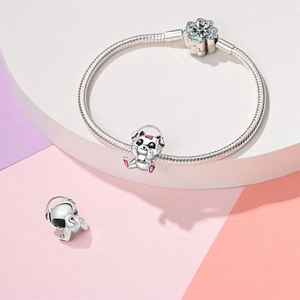 Detail van katten-muziekbedel en bloemsluiting op verzilverde slangenketting armband