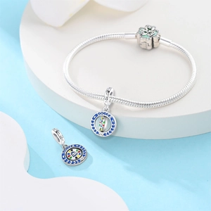 Detalle de pulsera de plata 925 con dije de fútbol giratorio y cierre de flor esmaltada en verde