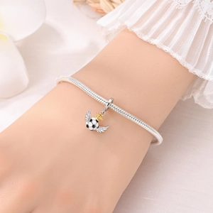 Detalle de pulsera de cadena de serpiente con colgante de fútbol alado y corona