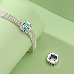 Silver mesh bracelet with a lucky horseshoe charm and green four-leaf clover inlay