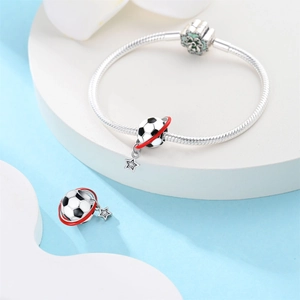 Primer plano detallado de una pulsera de serpiente plateada con dije de fútbol y estrella