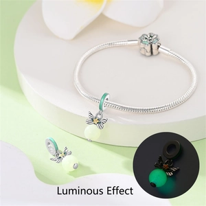 Detail of S925 silver butterfly charm with luminous bead on a snake bone bracelet