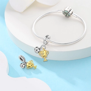 Detalle de pulsera de plata con colgante de balón de fútbol y trofeo de oro WIN