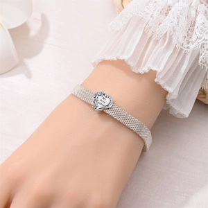 Detail of silver mesh bracelet featuring a heart charm engraved with My Best Sister