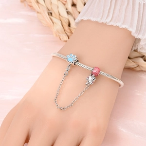 Détail du charm patte de chat et perle rose sur bracelet maille serpent argentée