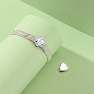 Detail of silver mesh bracelet with My Best Sister heart charm and colorful star patterns