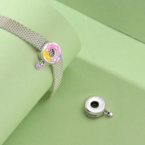 Detailed macro of S925 silver mesh bracelet with colorful enamel donut heart charms