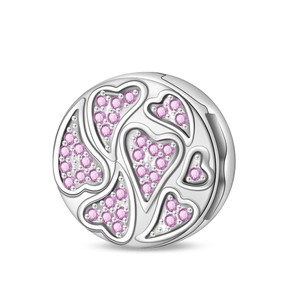 Macro detail of silver charm with pink heart crystals and intricate polished finish