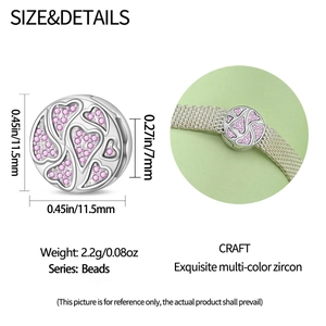 Macro detail of silver heart charm with pink zircon inlays and precise dimensions