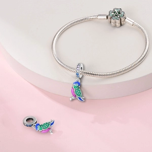 Detailed shot of enamel parrot charms on a snake chain bracelet with flower clasp