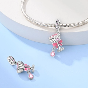 Close-up of pink bow beer glass charms with heart gemstones on silver snake chain
