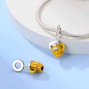 Macro detail of silver beer mug charm with yellow enamel and sparkling zircon accents