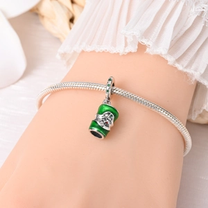 Detail of silver snake chain bracelet featuring a green enamel beer mug charm