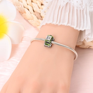 Close-up of silver snake chain bracelet featuring a green enamel Jeep charm with Just Go text