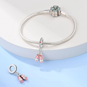 Macro shot of silver ballet slippers charm with pink enamel and sparkling crystals