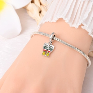 Detailed view of a silver beer mug charm with enamel accents on a snake bone bracelet