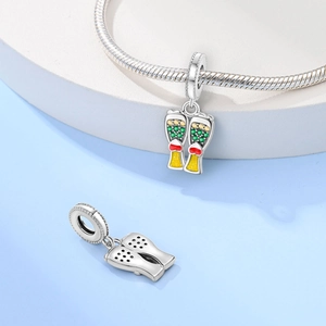 Macro view of silver beer mug charm with yellow enamel and heart detail on a snake chain