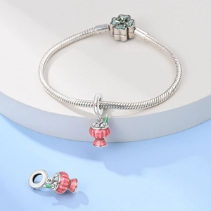 Silver snake chain bracelet featuring a pink enamel charm and green floral clasp detail