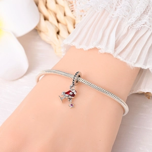 Detailed shot of Christmas boot charm with red enamel and star on a snake chain bracelet