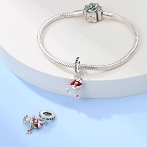 Close-up of a silver charm bracelet with a red wine glass charm on a geometric stand