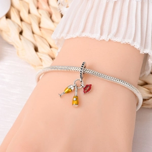 Detailed close-up of a silver snake chain bracelet with beer glass and red lip charms